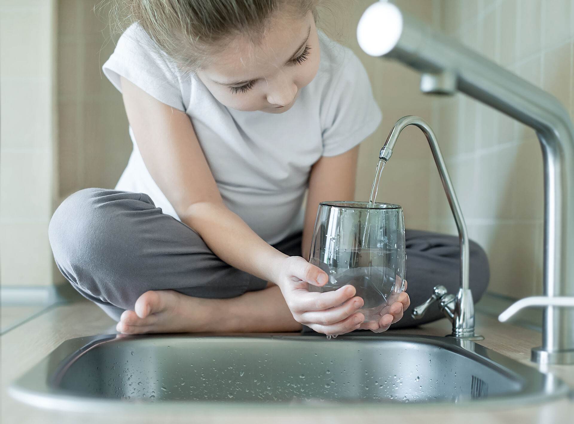 Filling glass at kitchen sink